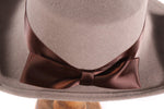 Grey hat with flat back rim and brown bow  detail